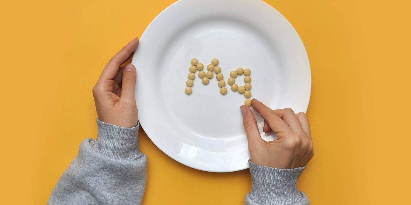 Магній на тарілці з пігулок — символ користі магнію для м’язів, нервової та травної системи.