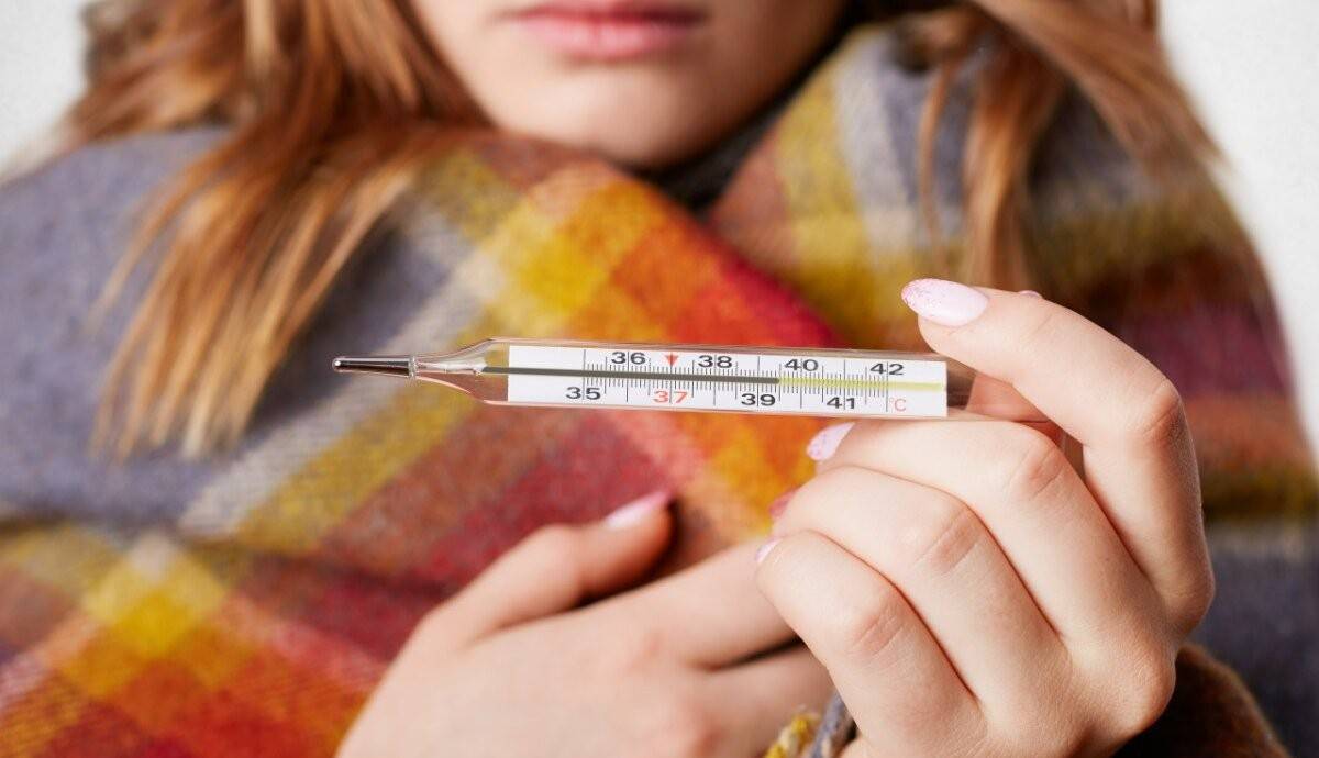 Висока температура при грипі – вимірювання температури тіла термометром.