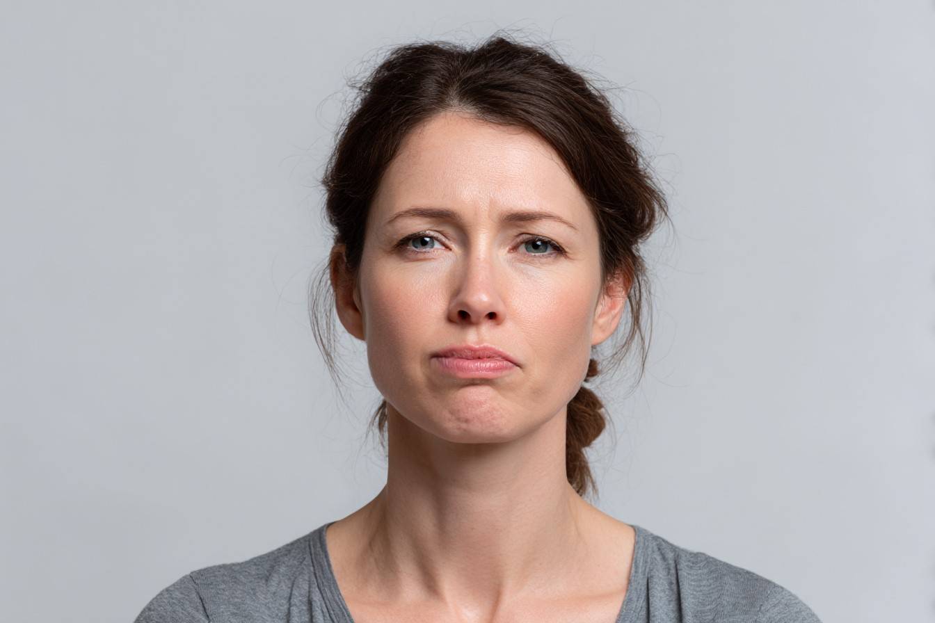 Жінка з асиметрією обличчя та опущеним куточком рота — можливий симптом невриту лицьового нерва