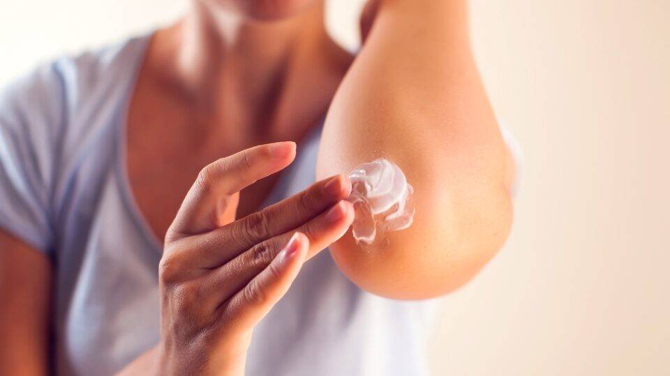 Забій ліктя після травми – нанесення мазі для зняття болю та запалення.