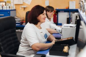 Жінка в білому халаті за робочим столом